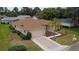 Exterior view of a tan home with well-maintained landscaping and a two-car garage at 9891 Se 138Th Loop, Summerfield, FL 34491