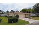 Tan home features a well-manicured lawn and a two-car garage on a corner lot at 9891 Se 138Th Loop, Summerfield, FL 34491