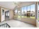 Enclosed lanai offers views of the backyard and features neutral decor with a ceiling fan at 9891 Se 138Th Loop, Summerfield, FL 34491