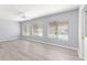 Spacious living room with modern ceiling fan, gray walls, and large windows with coverings at 9891 Se 138Th Loop, Summerfield, FL 34491