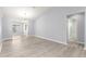 Bright living room area with modern flooring, pendant lighting, and easy access to the bathroom at 9891 Se 138Th Loop, Summerfield, FL 34491