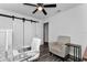 Bright bedroom with white walls, barn door closet, ceiling fan and glass top desk with office chair at 111 Almond Rd, Ocala, FL 34472