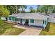 Charming single-story home with a manicured lawn, attached garage, and inviting front porch seating at 111 Almond Rd, Ocala, FL 34472