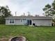 View of the home's backyard with a small patio, outdoor furniture, and a fire pit at 120 Fisher Ct, Ocklawaha, FL 32179