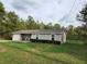 Cozy one-story house featuring an attached garage, a neatly landscaped lawn, and a welcoming front porch at 120 Fisher Ct, Ocklawaha, FL 32179