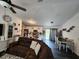 Bright and airy living room with vinyl flooring, ceiling fan, and an open view into the kitchen at 120 Fisher Ct, Ocklawaha, FL 32179