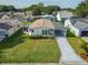 Aerial shot showcases the lovely home with carport, neat landscaping, and inviting curb appeal at 1228 Maria Ct, Lady Lake, FL 32159