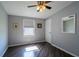 Bright bedroom featuring wood-look floors, modern ceiling fan, and a large window at 1228 Maria Ct, Lady Lake, FL 32159