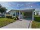 Well-maintained home with a covered carport and pristine landscaping, offering convenient parking at 1228 Maria Ct, Lady Lake, FL 32159