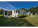 Charming yellow home featuring a screened-in porch and well-maintained landscaping in a quiet neighborhood at 1228 Maria Ct, Lady Lake, FL 32159