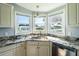 Kitchen sink area with granite countertops, stainless steel appliances, and a view of the neighborhood at 1228 Maria Ct, Lady Lake, FL 32159