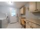 Bright laundry room with a modern washer and dryer, built-in desk, and exterior door access at 1228 Maria Ct, Lady Lake, FL 32159