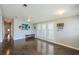 Bright living room featuring hardwood floors, large windows, ceiling fan and a hallway at 1228 Maria Ct, Lady Lake, FL 32159