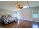 Bright main bedroom with wood-look floors, ceiling fan, and natural light from multiple windows at 1228 Maria Ct, Lady Lake, FL 32159