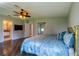 Spacious main bedroom featuring wood-look floors, closet, access to en suite bathroom, and ceiling fan at 1228 Maria Ct, Lady Lake, FL 32159