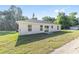 Single-story home featuring a well-maintained lawn, backyard patio, and simple modern design at 12974 Se 42Nd Ct, Belleview, FL 34420
