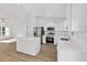 Open kitchen with white cabinets, stainless steel appliances, quartz countertops, and a large island at 12974 Se 42Nd Ct, Belleview, FL 34420