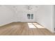 Bright living space features a ceiling fan, white walls, wood-look floors, and a window at 12974 Se 42Nd Ct, Belleview, FL 34420
