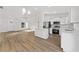 Open-concept living room showcasing natural light, wood-look floors, modern finishes, and white walls at 12974 Se 42Nd Ct, Belleview, FL 34420