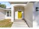 Close-up of the inviting bright yellow front door with a decorative light fixture at 12988 Se 42Nd Ct, Belleview, FL 34420