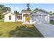 Charming single-story home featuring a bright yellow door and attached two-car garage at 12988 Se 42Nd Ct, Belleview, FL 34420
