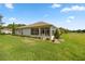 Exterior view of a home's backyard, featuring a sunroom, well-kept lawn, and golf course access at 13015 Se 93Rd Cir, Summerfield, FL 34491