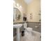 Stylish powder room featuring a pedestal sink and decorative wallpaper at 13015 Se 93Rd Cir, Summerfield, FL 34491
