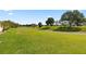 Scenic golf course view with lush green fairways and mature trees under a bright blue sky at 13015 Se 93Rd Cir, Summerfield, FL 34491
