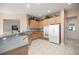 Open kitchen with stainless appliances, breakfast bar, and light wood cabinetry at 13015 Se 93Rd Cir, Summerfield, FL 34491