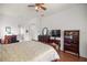 Comfortable main bedroom features ceiling fan, wood floors, and dark wood furniture at 13015 Se 93Rd Cir, Summerfield, FL 34491