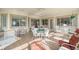 Sunroom with tiled floor, ample seating and views of the surrounding greenery at 13015 Se 93Rd Cir, Summerfield, FL 34491