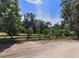 Beautiful backyard with a wood fence enclosing a grassy area and mature trees in the background at 13385 Ne 10Th Ct, Citra, FL 32113