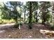 Secluded backyard area with a bench, statue, and trees, offering a peaceful and private outdoor space at 13385 Ne 10Th Ct, Citra, FL 32113