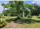 Inviting backyard space featuring a shade tree and seating area, perfect for relaxing and outdoor enjoyment at 13385 Ne 10Th Ct, Citra, FL 32113