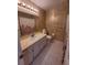 Neutral bathroom featuring single sink vanity, wallpaper, and white tiled floor at 13385 Ne 10Th Ct, Citra, FL 32113