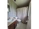 Neutral bathroom featuring single sink vanity, wallpaper, and white tiled floor at 13385 Ne 10Th Ct, Citra, FL 32113