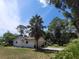 This single-story home features a side garage, palm tree, and inviting curb appeal at 13385 Ne 10Th Ct, Citra, FL 32113