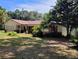 Charming single-story home with brick accents, red shutters, and lush landscaping at 13385 Ne 10Th Ct, Citra, FL 32113