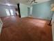 Spacious living room with carpet flooring, ceiling fan, and access to the backyard at 13385 Ne 10Th Ct, Citra, FL 32113