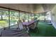 Enclosed porch offers a delightful outdoor living space with table, chairs, and green carpet at 13385 Ne 10Th Ct, Citra, FL 32113