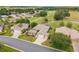 Aerial view of a well-kept house featuring a manicured front yard, landscaping, and proximity to a golf course at 13495 Se 93Rd Court Rd, Summerfield, FL 34491