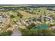 An aerial view displays lush landscaping, golf course access, and a serene pond within this community at 13495 Se 93Rd Court Rd, Summerfield, FL 34491