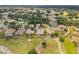 Beautiful aerial view of a golf community, showcasing lush landscaping, serene pond, and well-maintained homes at 13495 Se 93Rd Court Rd, Summerfield, FL 34491