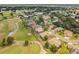Aerial view of homes nestled near golf course and pond surrounded by lush trees at 13495 Se 93Rd Court Rd, Summerfield, FL 34491