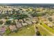 Aerial view showcases a neighborhood near golf course and a pond surrounded by lush trees at 13495 Se 93Rd Court Rd, Summerfield, FL 34491