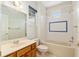 Bright bathroom featuring a tub with tile surround, vanity with neutral countertop, and window offering natural light at 13495 Se 93Rd Court Rd, Summerfield, FL 34491