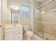 Cozy bathroom features a single vanity, a toilet, and a walk-in shower with glass doors at 13495 Se 93Rd Court Rd, Summerfield, FL 34491