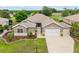 Inviting home features a manicured lawn, tasteful landscaping, and a spacious driveway leading to a garage at 13495 Se 93Rd Court Rd, Summerfield, FL 34491
