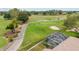 Aerial view of lush golf course community featuring mature trees, green fairways, and screened-in outdoor seating area at 13495 Se 93Rd Court Rd, Summerfield, FL 34491