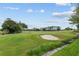 Scenic view of lush green golf course with sand trap, showcasing the community's recreational amenities and landscape at 13495 Se 93Rd Court Rd, Summerfield, FL 34491